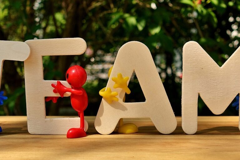 TEAM The word TEAM in wooden letters hugged by a few little people